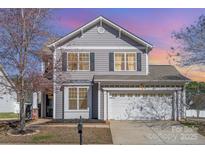 Charming two-story home featuring gray siding, black shutters and a two-car garage at 4586 Little Leaf Ln, Rock Hill, SC 29732