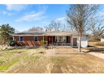 Charming one-story brick home with a cozy front porch, inviting curb appeal and mature trees at 5923 Charleston Ave, Kannapolis, NC 28081