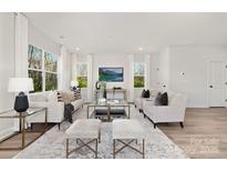 Bright living room with neutral furniture, a glass coffee table, and large windows with natural light at 6117 Grove Park Blvd, Charlotte, NC 28215