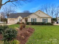 Charming single-story home with well-manicured lawn, garden bed, and attached garage at 8723 Totteridge Dr, Charlotte, NC 28277