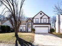 Charming two-story home with manicured lawn, arched entryway, two car garage, and gray and white trim at 13807 Queenswater Ln, Charlotte, NC 28273