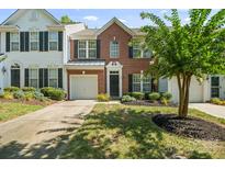 Traditional brick townhome with an attached garage, manicured landscaping, and a welcoming entrance at 140 N Arcadian Way, Mooresville, NC 28117