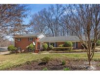 Charming brick home featuring mature landscaping and a well-manicured front lawn at 211 Kingsway Cir, Charlotte, NC 28214