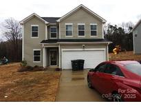 Two-story home featuring a two car garage and a cozy front yard at 212 Sugar Hill Rd, Troutman, NC 28166
