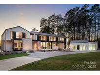 Stunning modern home with stone accents, large windows, and manicured lawn and a detached three-car garage at 2536 Brawley School Rd, Mooresville, NC 28117