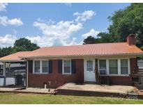 Charming brick home with a striking metal roof and an inviting front porch at 3101 Harvell St, Gastonia, NC 28052