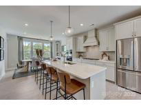 Bright kitchen featuring a large island with seating, stainless steel appliances, and ample cabinet space at 344 Catawba Ave, Davidson, NC 28036