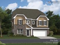 Two-story home featuring a mix of stone and siding, complemented by a two-car garage and a well-manicured lawn at 4641 Potters Wheel Ct, Fort Mill, SC 29715