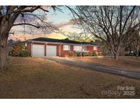 Charming red brick ranch home with a two-car garage and a well-manicured front yard at 10501 Us Highway 52 Hwy, Rockwell, NC 28138