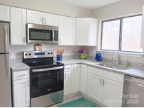 This kitchen features white cabinets, granite countertops, and stainless steel appliances at 3240 Heathstead Pl, Charlotte, NC 28210