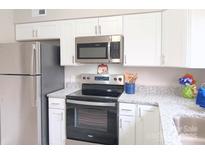 Modern kitchen with stainless steel appliances and white cabinets offers an efficient workspace at 3240 Heathstead Pl, Charlotte, NC 28210