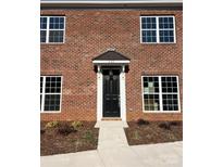 Charming brick home featuring a black front door with a classic awning and white trim at 435 Beacon Nw St, Concord, NC 28027