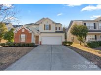 Inviting two-story home featuring a two-car garage, well-manicured landscaping, and a mix of siding and brick accents at 4513 Staffordshire Ln, Charlotte, NC 28213