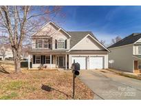 Traditional two-story home featuring a two-car garage and inviting front porch at 5023 Wicklow Dr, Gastonia, NC 28054