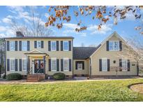Charming two-story home featuring black shutters, complemented by a well-maintained green lawn and manicured landscaping at 907 Paul Revere Ln, Gastonia, NC 28056