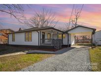 Charming one-story home featuring a cozy front porch and adjacent covered carport, nestled on a well-maintained lot at 922 Grace Ave, Kannapolis, NC 28083