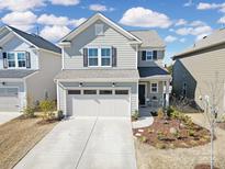Charming two-story home boasts a welcoming front yard and a two-car garage at 14032 Canemeadow Dr, Charlotte, NC 28278
