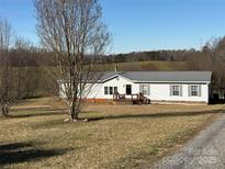 Quaint single-story home featuring a metal roof, front porch, and a spacious yard with mature trees at 2084 W Memorial Hwy Rd, Union Grove, NC 28689