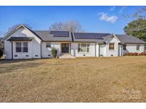 Charming brick home featuring solar panels, well-manicured lawn, and welcoming entrance at 2297 Blossom Dr, Rock Hill, SC 29730