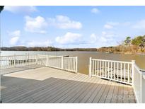 A picturesque view from the spacious wooden deck overlooking a serene lake at 3113 South Point Rd, Belmont, NC 28012