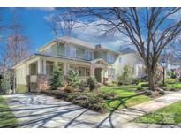 Charming two-story home with a covered front porch and manicured landscaping on a sunny day at 324 Wendover Hill Ct, Charlotte, NC 28211