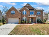 Beautiful two-story brick home featuring a well-maintained lawn and attached two-car garage at 4435 Mill Landing Dr, Harrisburg, NC 28075
