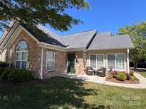 Charming home features a stone facade, well-kept lawn, and inviting front porch seating area at 5518 Prosperity View Dr, Charlotte, NC 28269