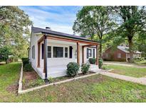 Charming single-story home featuring a welcoming front porch and well-maintained landscaping at 5726 Oak Dr, Charlotte, NC 28216