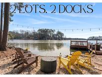 Scenic lake view featuring two docks, shoreline seating, and waterfront ambiance at 693 Emerald Shores Rd, Mount Gilead, NC 27306