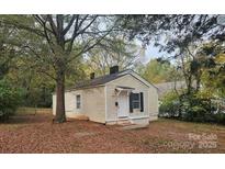 Charming single-story home featuring light siding, mature trees, and a cozy front porch at 814 Cantwell St, Charlotte, NC 28208
