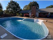 Inviting pool with a waterfall feature, surrounded by a spacious patio and lush greenery at 102 3Rd Se Ave, Catawba, NC 28609