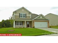 Charming two-story home featuring a two-car garage, a welcoming front porch, and a well-manicured lawn at 1348 Secrest Commons Dr, Monroe, NC 28112