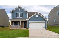 Charming two-story home with blue siding, brick accents, and a well-manicured lawn at 1348 Secrest Commons Dr, Monroe, NC 28112