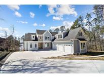 Beautiful exterior view of a light blue two-story home with three-car garage and a long concrete driveway at 154 Fox Hunt Dr, Mooresville, NC 28117