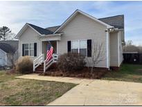 Charming single-Gathering home features black shutters and an inviting front porch with American flag at 1638 Marmot Pl, Concord, NC 28025