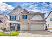 Charming two-story home with stone accents, attached two-car garage, and well-maintained landscaping at 2050 Saddlebred Dr, Iron Station, NC 28080