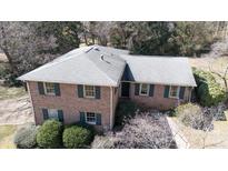 Aerial view of a two-story brick home featuring a well-maintained roof and lush, mature landscaping at 2105 Monticello Dr, Gastonia, NC 28056