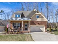 Charming brick home featuring a covered front porch and a two-car garage at 2111 Augusta National Dr, Denver, NC 28037