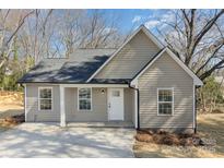 Charming one-story home featuring a neutral color, inviting front porch, and a well-maintained concrete driveway at 290 Houston Ne St, Concord, NC 28025