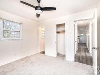 A spacious bedroom with a ceiling fan and ample natural light streaming through the window at 303 S Eastway Dr, Troutman, NC 28166