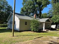 Charming single-story home with freshly painted siding, mature trees, and a brick chimney at 345 Mountain View St, Gastonia, NC 28052