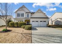 Charming two-story home with a two-car garage, landscaped yard, and inviting front porch at 5006 Sand Trap Ct # 142, Monroe, NC 28112
