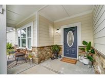 Inviting front porch with stone accents, decorative plants, and a cozy seating area at 5006 Sand Trap Ct # 142, Monroe, NC 28112