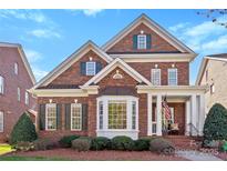 Charming two-story brick home featuring a covered front porch and manicured landscaping at 108 Berkshire Ave, Belmont, NC 28012