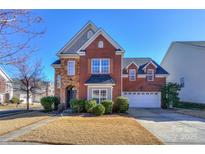 Charming two-story brick home boasts manicured landscaping and an attached two-car garage at 13344 Craig Mill Ln, Huntersville, NC 28078