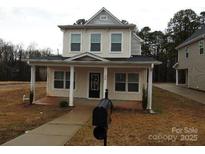 Charming two-story home with a cozy front porch and well-maintained landscaping at 260 Mills Ave, Troutman, NC 28166