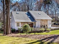 Charming stone and siding home featuring mature trees, well-maintained landscaping, and a welcoming facade at 3011 Lauren Glen Rd, Charlotte, NC 28226