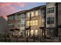 Beautiful exterior of a modern brick townhome featuring large windows and a wrought iron fence at 3729 S Tryon St, Charlotte, NC 28217