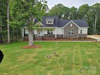Charming single-Gathering home showcasing a stone facade and inviting front porch overlooking a spacious front yard at 601 Shiloh Unity Rd, Lancaster, SC 29720