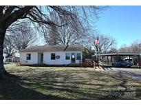 Charming single-story home with a white exterior, complemented by a spacious yard and an open carport at 1433 Buffalo Shoals Rd, Catawba, NC 28609